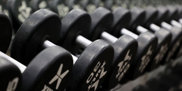 Dumbbells rest on a rack on May 13, 2020, in West Islip, New York. Air Force veteran Johnny Miller lifted 2,492.4 pounds in one minute in December, officially breaking the Guinness World Record.