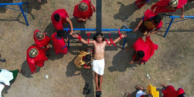 Ruben Enaje is nailed to the cross during a reenactment of Jesus Christ's sufferings as part of Good Friday rituals on April 7, 2023, in the village of San Pedro, Philippines.