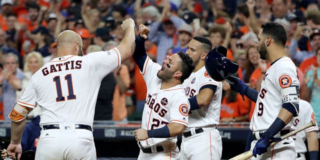 Evan Gattis #11 of the Houston Astros celebrates with Jose Altuve #27, Carlos Correa #1 and Marwin Gonzalez #9 after hitting a solo home run against CC Sabathia #52 of the New York Yankees during the fourth inning of Game Seven of the American Series League Championship game at Minute Maid Park on October 21, 2017 in Houston, Texas.  