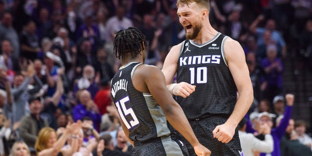 El alero de los Sacramento Kings, Domantas Sabonis (10), felicita al escolta Davion Mitchell (15) en la primera mitad durante el Juego 1 de la primera ronda de los playoffs de baloncesto de la NBA contra los Golden State Warriors en Sacramento, California, el lunes 17 de abril de 2023. 