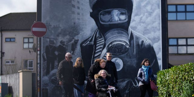 El primer ministro británico, Sunak, insta a los políticos de Irlanda del Norte a volver al trabajo 4 Los turistas pasan junto a un mural en la esquina de Londonderry, Derry en Irlanda del Norte. El primer ministro británico conservador, Rishi Sunak, rindió homenaje el lunes a los políticos de Irlanda del Norte que negociaron el Acuerdo del Viernes Santo de 1998 e instó a los políticos en ejercicio a volver al trabajo.