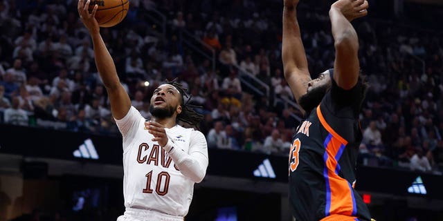 Cleveland Cavaliers guard Darius Garland (10) shoots against New York Knicks center Mitchell Robinson during the first half of Game 2 of an NBA basketball first-round playoff series Tuesday, April 18, 2023, in Cleveland. 