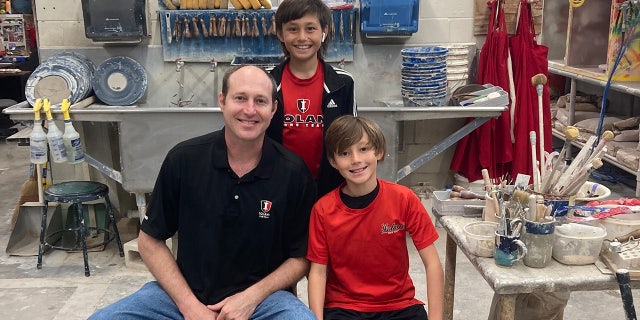 Ryan Roberts, ceramics teacher at the Iolani School in Honolulu, hangs out in his studio with sons Asher, 10, and Owen, 13. The boys were in the car when Roberts stopped on the side of the road to save a 100-year-old woman who was choking.