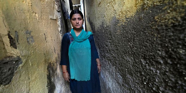Sheela Singh, 39, stands in a narrow lane in Mumbai, India, on March 19, 2023. Singh was pressured to quit her job to care for her children as India continues to grapple with a shrinking female workforce.