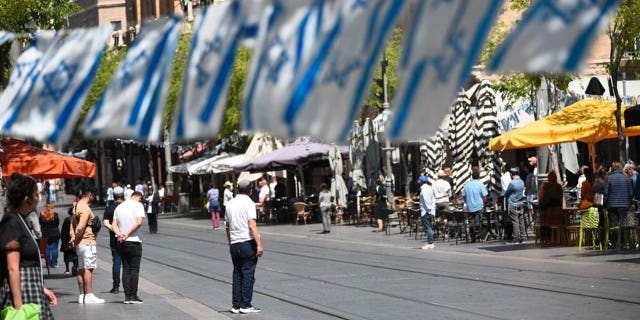 Israeli streets lined with Israeli flags and silent people