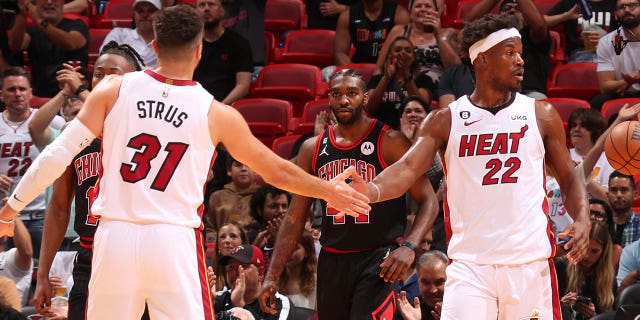 Max Strus and Jimmy Butler (22) of the Miami Heat high-five during a game against the Chicago Bulls during the 2023 play-in tournament April 14, 2023, at the Kaseya Center in Miami, Fla.