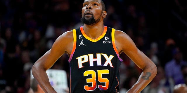 Phoenix Suns forveti Kevin Durant (35), 18 Nisan 2023 Salı günü Phoenix'te Los Angeles Clippers'a karşı oynanan NBA basketbol playoff birinci tur serisinin 2. Maçının ilk yarısında skor tahtasına bakıyor.