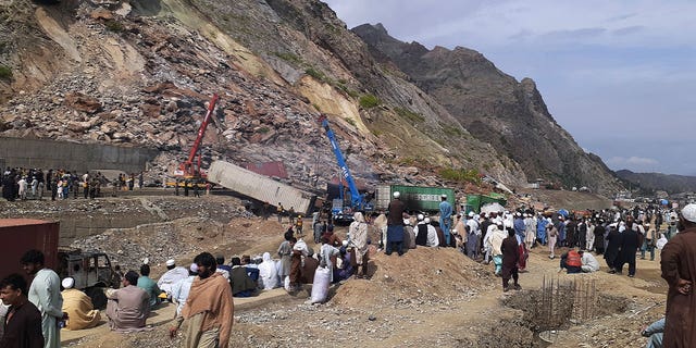 Stanovnici se okupljaju dok vlasti koriste teške strojeve za čišćenje ruševina nakon odrona koji je pogodio autocestu u blizini Torkhama, Pakistan, 18. travnja 2023. 