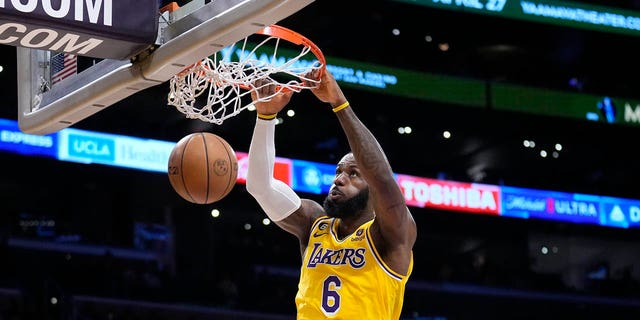 Los Angeles Lakers forward LeBron James (6) dunks over Minnesota Timberwolves guard Mike Conley, left, during the first half of an NBA basketball play-in tournament game Tuesday, April 11, 2023, in Los Angeles.