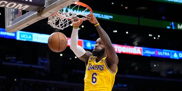 Los Angeles Lakers forward LeBron James (6) dunks over Minnesota Timberwolves guard Mike Conley, left, during the first half of an NBA basketball play-in tournament game Tuesday, April 11, 2023, in Los Angeles.