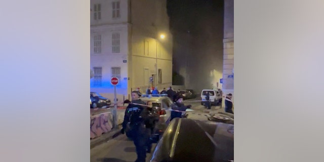 In this screengrab obtained from a social media video, smoke envelopes the area as police officers work at the scene of a fire following an explosion in Marseille, France, early Sunday.