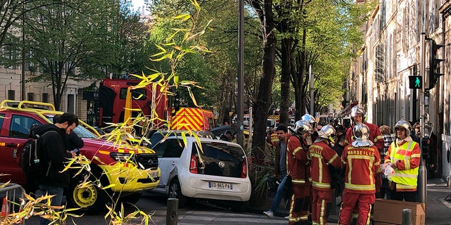 Firefighters gather near the street where a building collapsed early Sunday in Marseille as rescue efforts continued.
