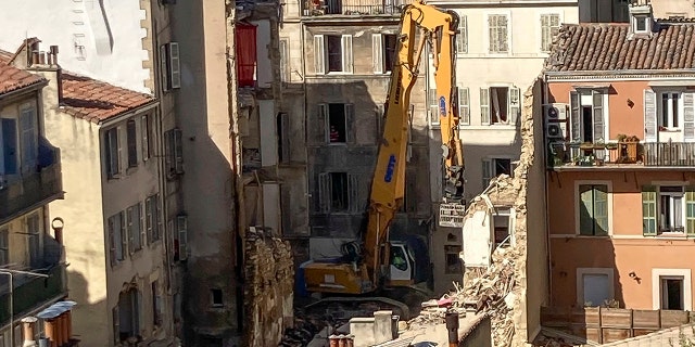 An excavator clears debris on the scene where a building collapsed, in Marseille, southern France, on Monday.