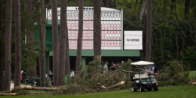 A sign that says "Play Suspended" on the leaderboard near fallen trees on the 17th hole during the second round of the 2023 Masters Tournament at Augusta National Golf Club April 7, 2023, in Augusta, Ga.