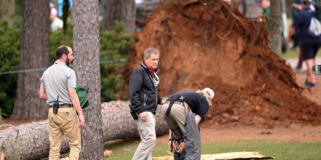AUGUSTA, GEORGIA - APRIL 07: Course officials look over fallen trees on the 17th hole during the second round of the 2023 Masters Tournament at Augusta National Golf Club on April 07, 2023 in Augusta, Georgia.