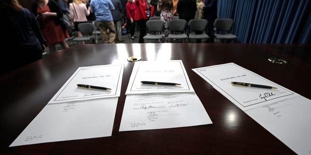 An official gubernatorial pen rests on each of the three bills signed by Mississippi Gov. Tate Reeves