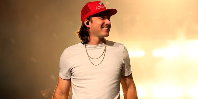Morgan Wallen smiles on stage during a concert