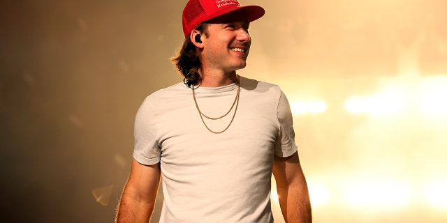 Morgan Wallen smiles on stage during a concert