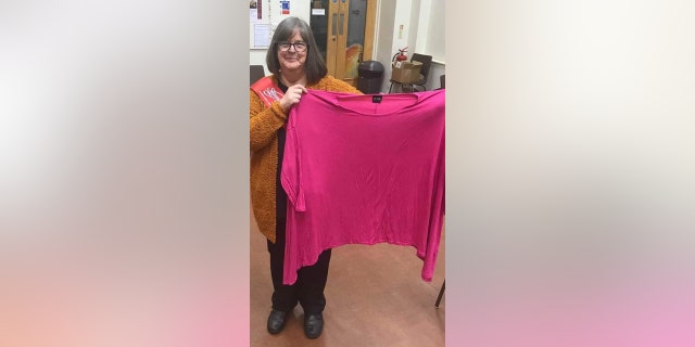 Lisa Childs holds up her old size 24 clothing — she now wears a size 12.