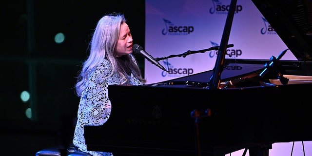 Natalie Merchant singing and playing the piano