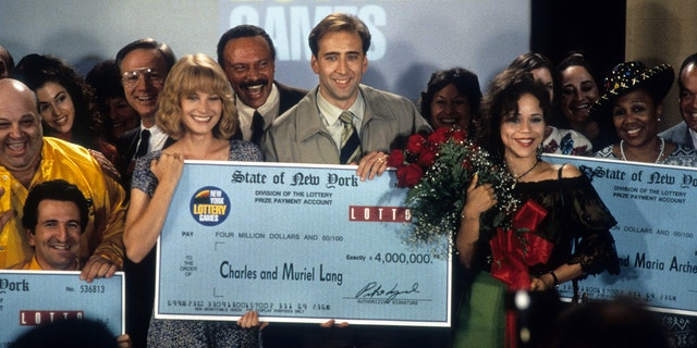 Bridget Fonda holds a lottery check with Nicolas Cage in It Could Happen to You movie still