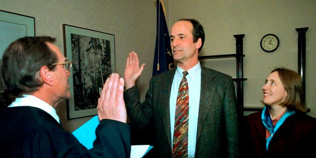 Bill Bradbury, center, holds hands with his wife Katy Eymann as he gets sworn in as Oregon's secretary of state by Supreme Court Justice Ted Kulongoski in Salem on Nov. 8, 1999. 