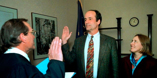 Bill Bradbury, center, holds hands with his wife Katy Eymann as he gets sworn in as Oregon's secretary of state by Supreme Court Justice Ted Kulongoski in Salem on Nov. 8, 1999.