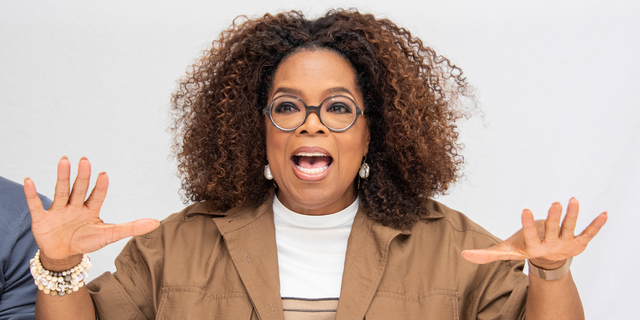 Oprah Winfrey waves her hands animatedly at an event.