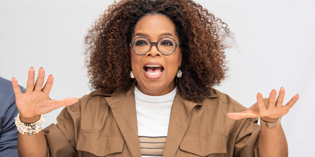 Oprah Winfrey waves her hands animatedly at an event.