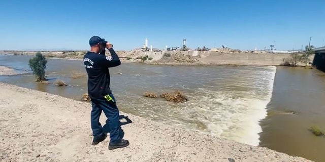 Fire officials used binoculars to search from the banks of the Salt River after determining the fast-moving water made conditions too dangerous for rescuers to enter water in south Phoenix.