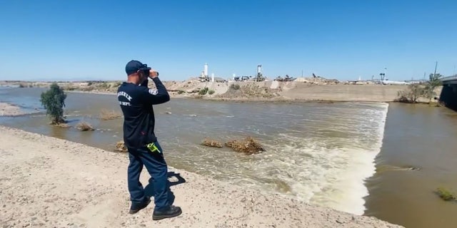 Fire officials used binoculars to search from the banks of the Salt River after determining the fast-moving water made conditions too dangerous for rescuers to enter water in south Phoenix.