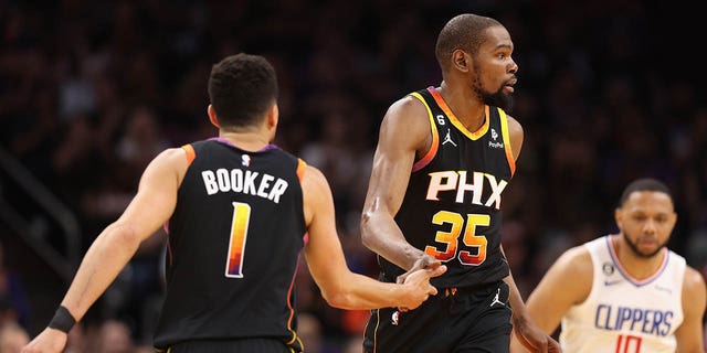 Kevin Durant #35 of the Phoenix Suns high-fives Devin Booker #1 after scoring against the LA Clippers during the first half of Game Two of the Western Conference First Round Playoffs at Footprint Center on April 18, 2023, in Phoenix, Arizona.