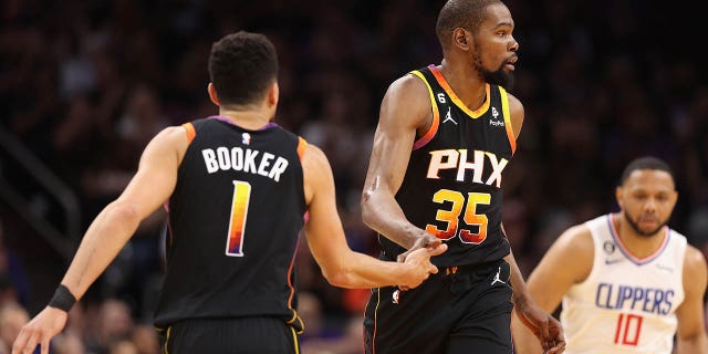 Kevin Durant #35 of the Phoenix Suns high-fives Devin Booker #1 after scoring against the LA Clippers during the first half of Game Two of the Western Conference First Round Playoffs at Footprint Center on April 18, 2023, in Phoenix, Arizona.