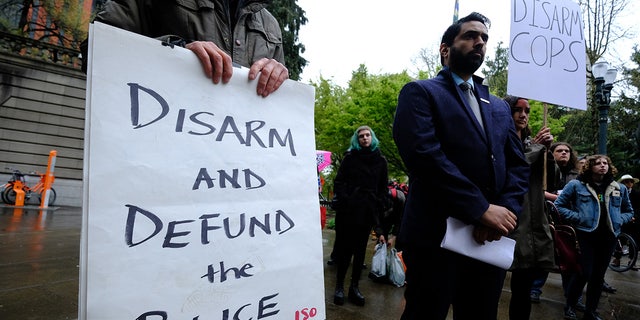 Protesters hold signs calling on police to be disarmed in Portland, Oregon.