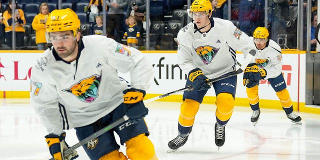 Cal Foote #52 and Kiefer Sherwood #44 of the Nashville Predators take the ice for warmups on Hockey Is For Everyone night prior to an NHL game against the Vegas Golden Knights at Bridgestone Arena on April 4, 2023 in Nashville, Tennessee.