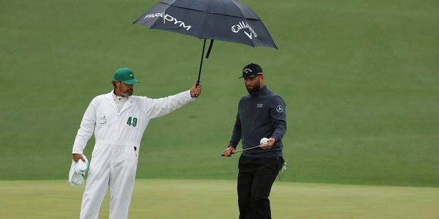 Jon Rahm of Spain looks over a putt on the second green with his caddie Adam Hayes during the third round of the 2023 Masters Tournament at Augusta National Golf Club April 8, 2023, in Augusta, Ga.