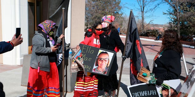 Seraphine Warren, center left, is embraced by state Sen. Shannon Pinto outside the state capitol building on Feb. 4, 2022, in Santa Fe, New Mexico. They participated in a rally to draw attention to murdered and missing Indigenous people including Warren’s aunt Ella Mae Begay.