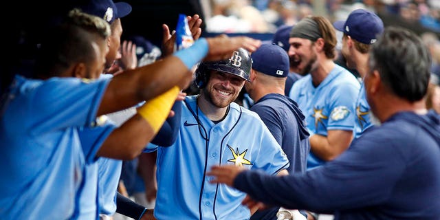 Brandon Lowe of the Tampa Bay Rays celebrates with teammates in the dugout after hitting a home run during the sixth inning against the Oakland Athletics at Tropicana Field April 8, 2023, in St Petersburg, Fla. 