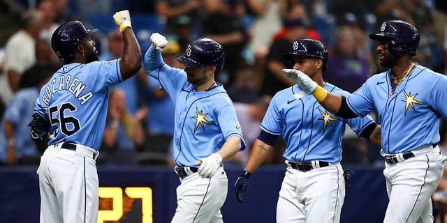 Brandon Lowe, center, of the Tampa Bay Rays celebrates with Randy Arozarena (56) after hitting a home run during the sixth inning against the Oakland Athletics at Tropicana Field April 8, 2023, in St Petersburg, Fla. 