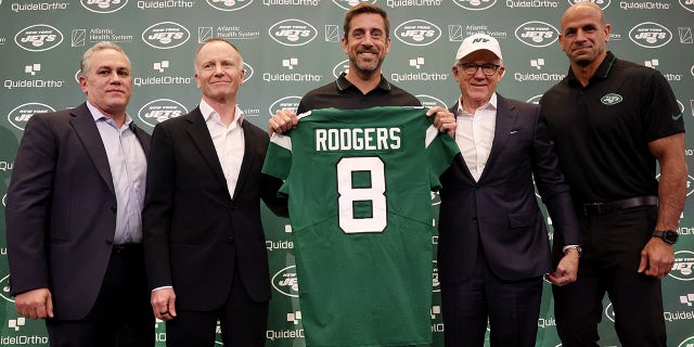 Aaron Rodgers holds Jets jersey