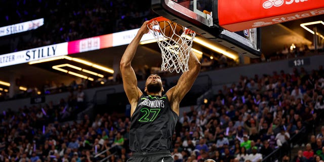 Rudy Gobert #27 of the Minnesota Timberwolves dunks the ball on an alley-oop while Shai Gilgeous-Alexander #2 of the Oklahoma City Thunder looks on in the second quarter of the NBA Play-In game at Target Center on April 14, 2023, in Minneapolis, Minnesota.