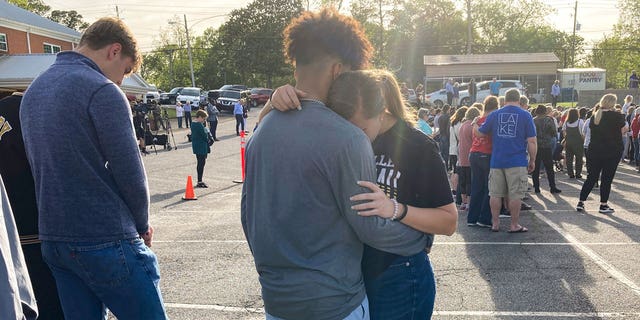 Two teens embrace at a prayer vigil on Sunday, April 16, 2023, outside First Baptist Church in Dadeville, Alabama.