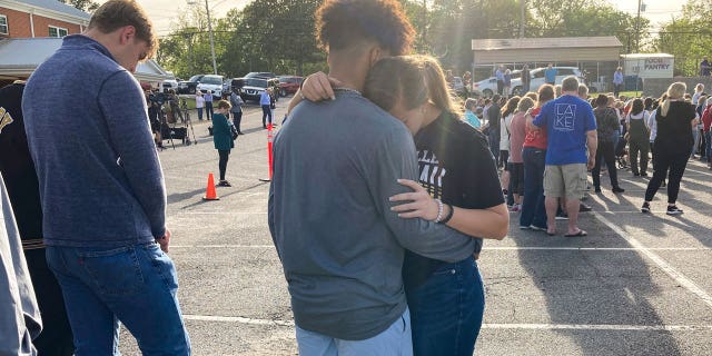 Two teens embrace at a prayer vigil on Sunday, April 16, 2023, outside First Baptist Church in Dadeville, Alabama.