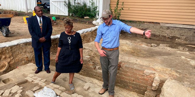 People stand at the brick-and-mortar foundation of one the oldest Black churches in the U.S. on Oct. 6, 2021, in Williamsburg, Virginia. Experts announced on April 6, 2023, that three men whose graves were found at the site were members of the church.