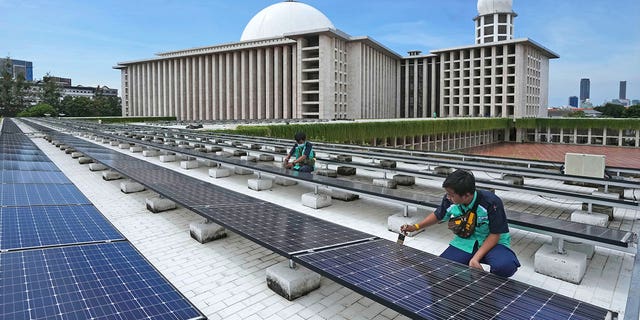 Radnici održavaju solarne panele koji djelomično opskrbljuju električnom energijom džamiju Istiqlal u Jakarti, Indonezija, 29. ožujka 2023. Poticaj klime u džamiji primjer je "Zeleni ramazan" inicijativa koja promiče muslimane da donose ekološki prihvatljivije odluke.