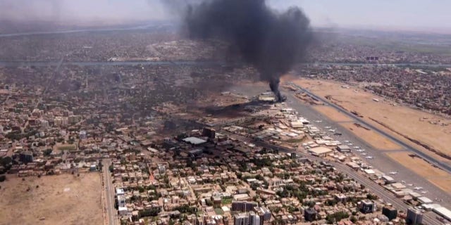 This image grab taken from AFPTV video footage on April 20, 2023, shows an aerial view of black smoke rising above the Khartoum International Airport