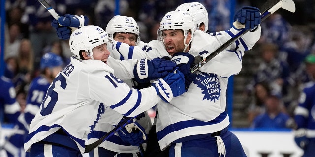 El centro de los Toronto Maple Leafs, John Tavares (91), celebra con el ala derecha Mitchell Marner (16)