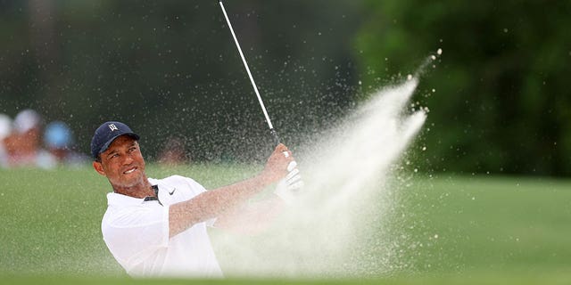 Tiger Woods of the United States plays a shot from a bunker on the 18th hole during the first round of the 2023 Masters Tournament at Augusta National Golf Club April 6, 2023, in Augusta, Ga.