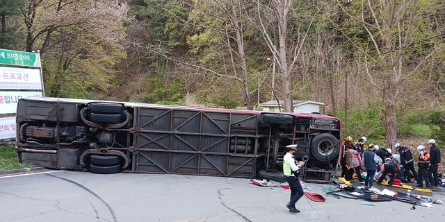 Osoblje hitne pomoći spašava turiste nakon što je autobus pao na cestu u Chungjuu, Južna Koreja, 13. travnja 2023. U incidentu je poginula 62-godišnja žena.