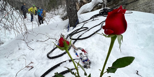 Flowers were placed in the snow near where the woman died after becoming trapped under two large blocks of fallen ice.